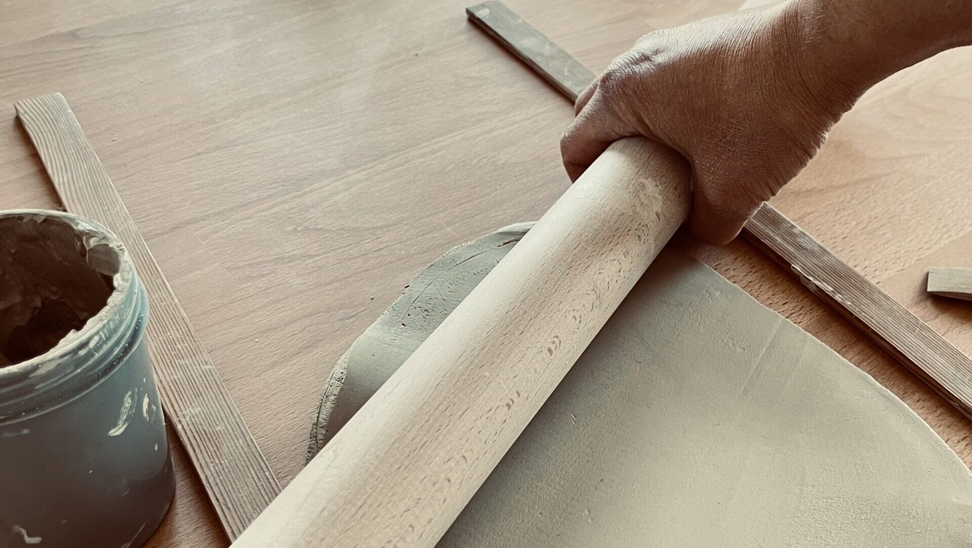 Hand rollt Ton mit Rollholz im Keramik-Basiskurs des Atelier MON Cottbus – handwerkliches Töpfern und Keramik formen lernen